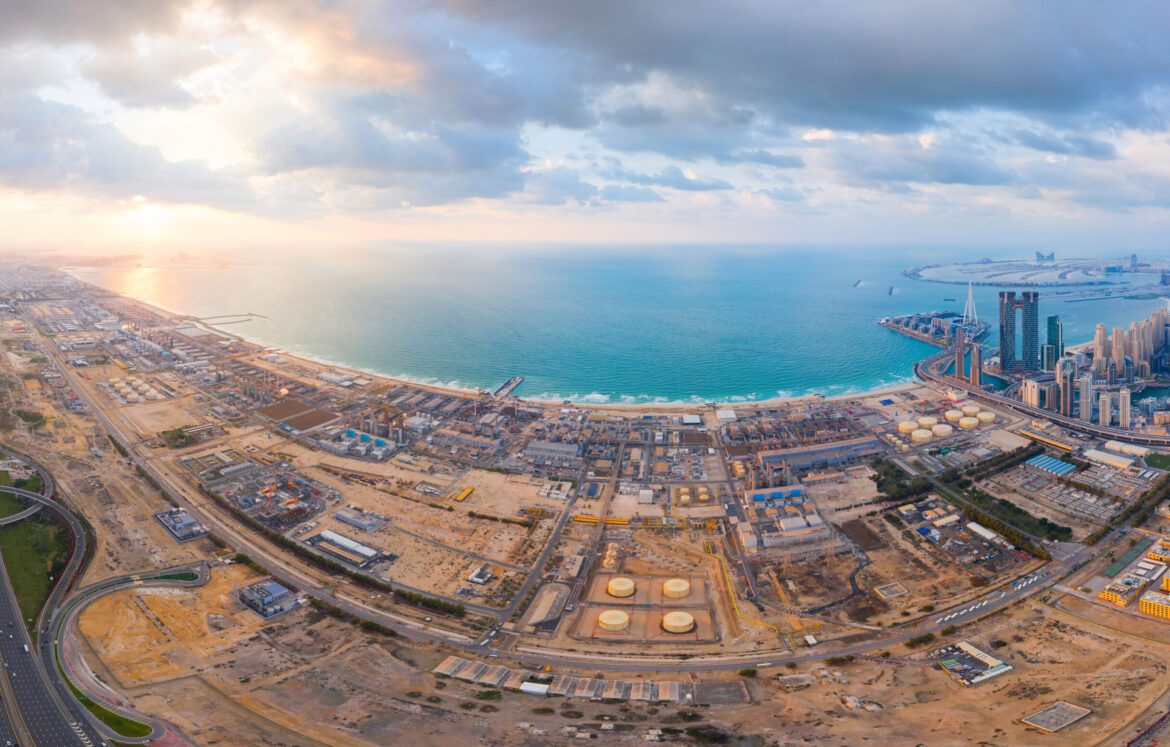 Aerial view of petrochemical oil refinery and sea in industrial engineering and energy concept in Dubai, urban city, UAE. Oil and gas tanks pipelines in industry. Modern metal factory. Power plant. Aerial view of petrochemical oil refinery and sea in industrial engineering and energy concept in Dubai, urban city, UAE. Oil and gas tanks pipelines in industry. Modern metal factory. Power plant.